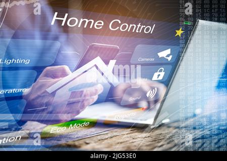Person Hand Holding Mobile Phone With Home Security System Stock Photo