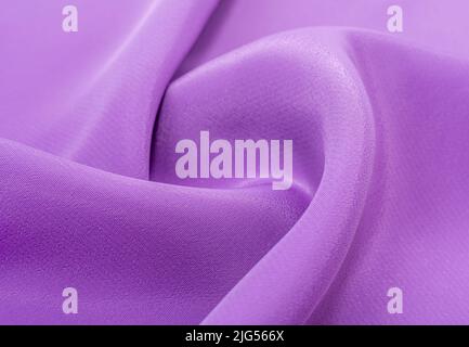Background from a crumpled piece of purple fabric. Material silk with waves and foldsBackground from a crumpled piece of purple fabric. Material silk Stock Photo