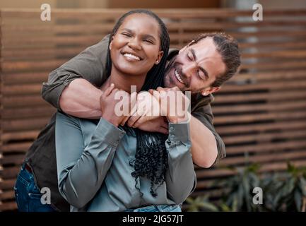 Definitely couple goals. Shot of a young couple standing outside of their new home. Stock Photo