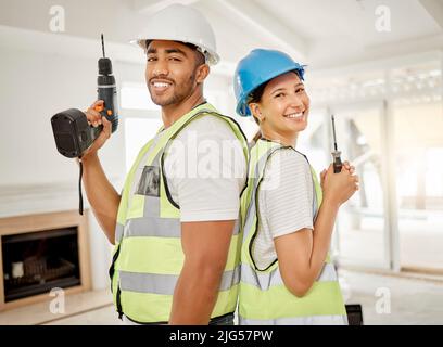 Lets get renovating. Shot of two construction workers standing back to back in a house and holding maintenance equipment. Stock Photo