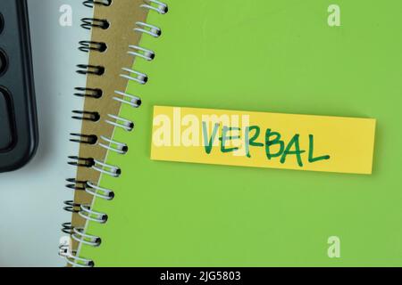 Concept of Verbal write on sticky notes isolated on Wooden Table. Stock Photo