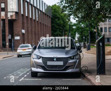 Peugeot e208 GT Electric Vehicle at Charging Point Stock Photo