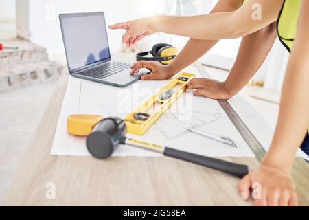 Can we go with this design. Cropped shot of two unrecognisable contractors standing inside together and using a laptop while planning. Stock Photo