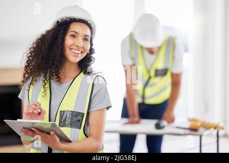 This place is going to look amazing when were done. Shot of an attractive young contractor standing inside and using a clipboard. Stock Photo