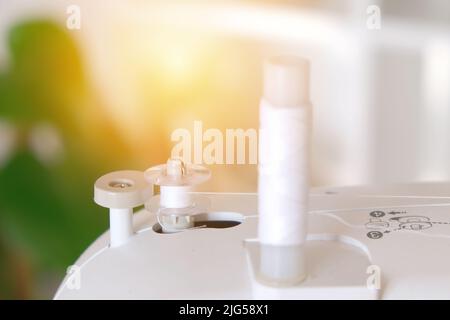 Winding threads on a bobbin on a sewing machine. Stock Photo