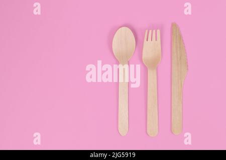 Wooden cutlery on side of pink background with copy space Stock Photo