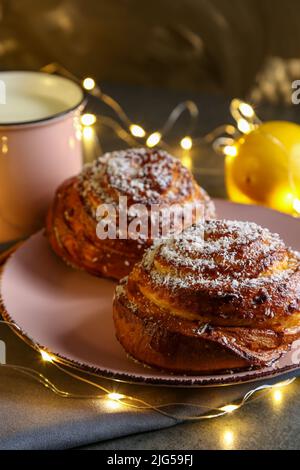 Cinnamon and coconut lemon buns on a pink plate on a gray table Stock Photo