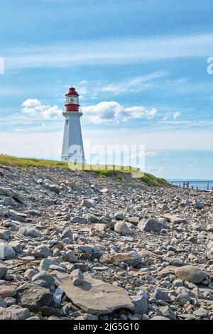 The Low Point Lighthouse is located near New Victoria Nova Scotia and marks the eastern entrance to Sydney Harbour.  Still in operation today it is on Stock Photo