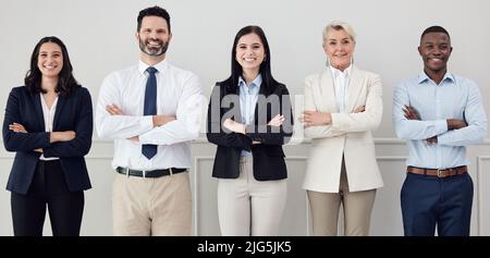 There is immense power when a group works together. Shot of a group of businesspeople standing with their arms crossed in an office at work. Stock Photo