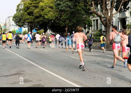 Scenes from the 2022 Bay to Breakers 12k foot race in San Francisco, California; participants, racers, walkers wearing costumes on Fell Street. Stock Photo