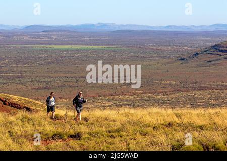 Hikers on the slopes of Mt Bruce, Karijini National Park Stock Photo