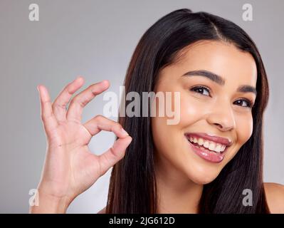 My hair is my best accessory. Studio portrait of an attractive young woman posing against a grey background. Stock Photo