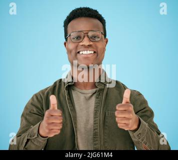 I have faith in you. Shot of a man showing thumbs up while posing against a blue background. Stock Photo