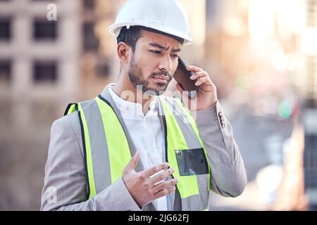 Changes Now. Cropped shot of a handsome male construction worker making a call while standing on a building site. Stock Photo