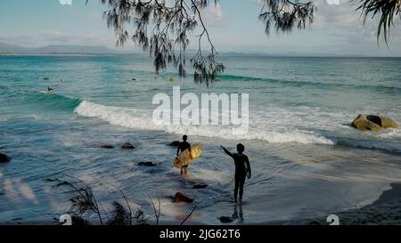 BYRON BAY, AUSTRALIA - NOV 3 2021: two longboard surfers check out the waves at wategos beach of byron bay Stock Photo