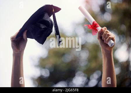 My limit is beyond the sky. Closeup shot of an unrecognisable graduate holding their cap and diploma on graduation day. Stock Photo