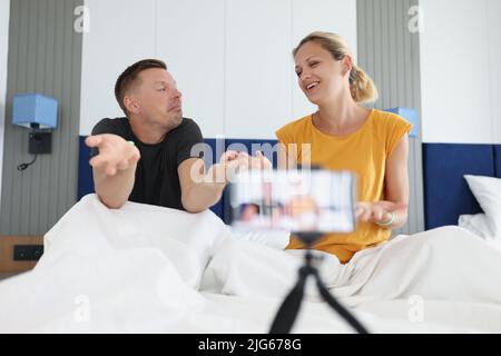 Couple recording video in bed on smartphone Stock Photo