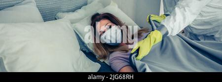 Doctors in bacteriological protective suits caring for a patient Stock Photo
