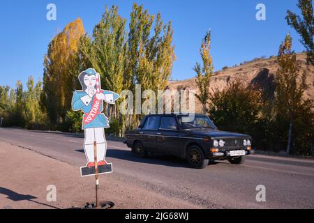 A metal cartoon, cutout, painted sign of a safety officer at a school crossing on a rural, country road, street. In Parkent, near Tashkent, Uzbekistan Stock Photo