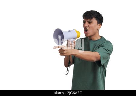 Young peruvian man shouting through megaphone and pointing, isolated. Stock Photo
