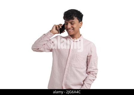 Young peruvian man smiling and speaking on the smartphone, isolated. Stock Photo