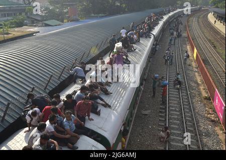 Dhaka. 8th July, 2022. Travelers sitting on the roof of a train leave a station in Dhaka, Bangladesh, July 7, 2022. As Eid al-Adha festival approaches, many people from Bangladesh capital Dhaka have streamed out of the city to join the festival with their kith and kin in village homes. Credit: Xinhua/Alamy Live News Stock Photo