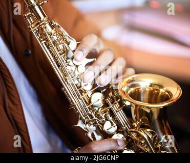 Making music with air. Cropped shot of an unrecognizable male musician playing his saxophone at home. Stock Photo