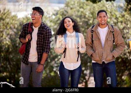 Strolling in sunshine. Shot of a group of students walking through campus together. Stock Photo