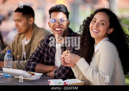 Its chow time. Shot of a group of students having a quick bite while studying together. Stock Photo