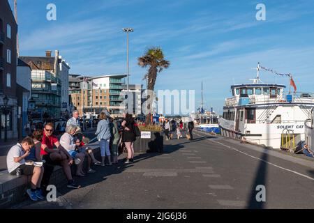 Families on summer holidays or staycations enjoying the seafront at Poole Quay, Dorset, England, UK, on a sunny day Stock Photo