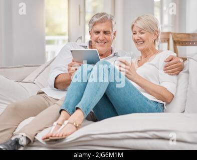 Your smile makes me smile. Shot of a elderly couple using a tablet at home. Stock Photo