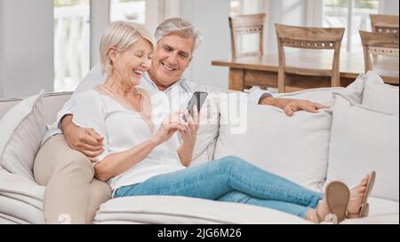 Together is my favorite place to be. Shot of a elderly couple using a cellphone at home. Stock Photo