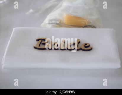 A napkin with a wooden place setting reading Bride at a wedding breakfast Stock Photo
