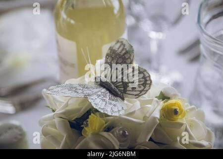 A close up of a wedding table decoration butterfly surrounded by other yellow decorations Stock Photo