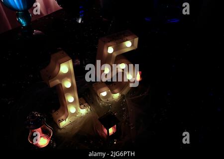 number fifteen with lights at 15th birthday party - light party - top view Stock Photo