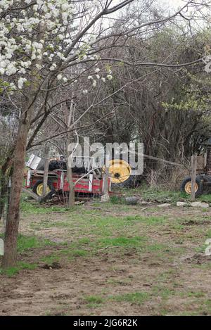 Storage of old farm equipment in the far corner of  the meadow. Stock Photo