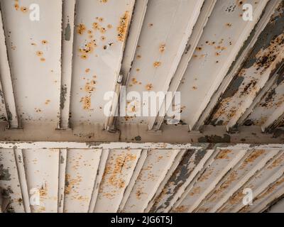 Rusty underside of a steel bridge with paint peeling off Stock Photo