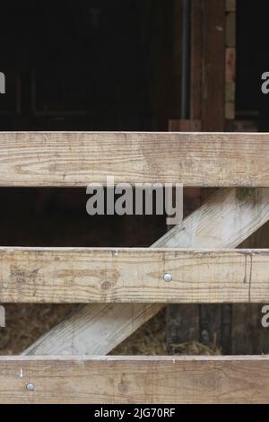 Typical wooden fence gate surrounding the pasture on the farm. Stock Photo