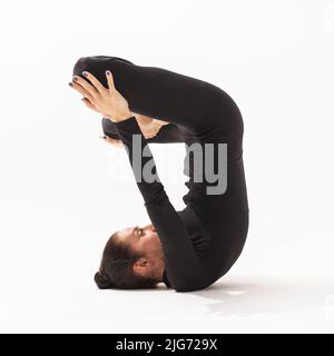 Woman practicing yoga doing Urdhva Padmasana exercise, inverted lotus pose, side view on white background Stock Photo