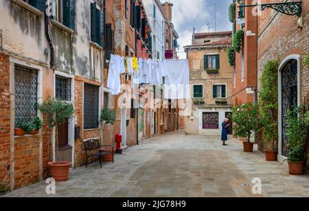 Laundry on a line in front of the typical Venetian house facades in the lagoon city of Venice, Venice, Italy Stock Photo