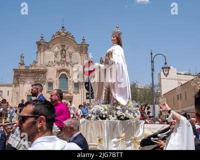 The initial procession of the statue of the Brown Madonna in Matera, Italy, in a horse carriage attended by a local Catholic bishop dressed in purple. Stock Photo