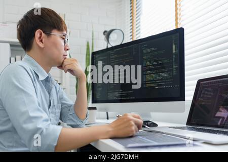 Software development concept, Male programmer read data code to thinking about developing website. Stock Photo