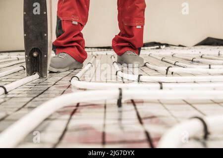 Radiant Floor Heating Pipe Installation Performed by Professional HVAC Worker Stock Photo