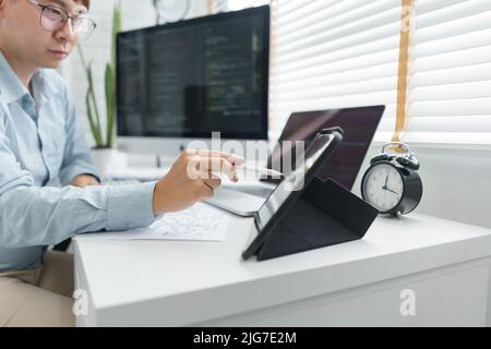 Software development concept, Male programmer point data on tablet to checking website programming. Stock Photo