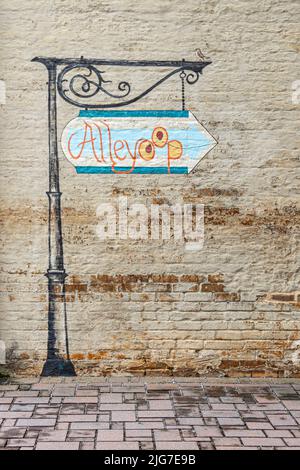 Alleyoop mural sign painted on a brick outside wall in Spartanburg, South Carolina looks like an ornate metal post with a colorful painted sign. Stock Photo
