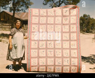 Mrs. Bill Stagg with state quilt that she made, Pie Town, New Mexico. A community settled by about 200 migrant Texas and Oklahoma farmers who filed homestead claims ... Mrs. Stagg helps her husband in the field with plowing planting, weeding corn and harvesting beans. She quilts while she rests during the noon hour. Stock Photo