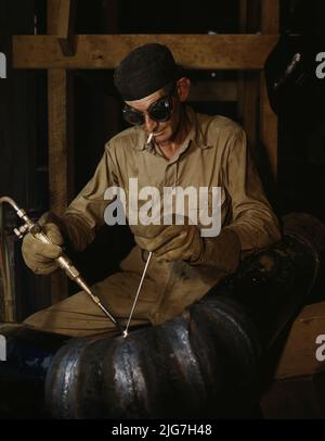 Gas welding a joint in a line of spiral pipe at the TVA's new Douglas Dam on the French Broad River, Tenn. This dam will be 161 feet high and 1,682 feet long, with a 31,600-acre reservoir area extending 43 miles upstream. With a useful storage capacity of approximately 1,330,000 acre-feet, this reservoir will make possible the addition of nearly 100,000 kw. of continuous power to the TVA system in dry years and almost 170,000 kw. in the average year. Stock Photo