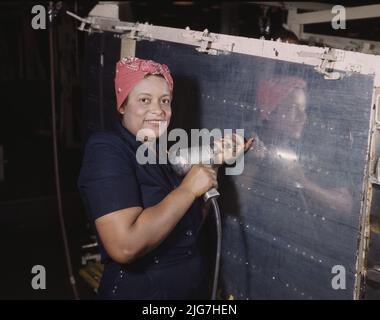 Operating a hand drill at Vultee-Nashville, woman is working on a &quot;Vengeance&quot; dive bomber, Tennessee. Stock Photo