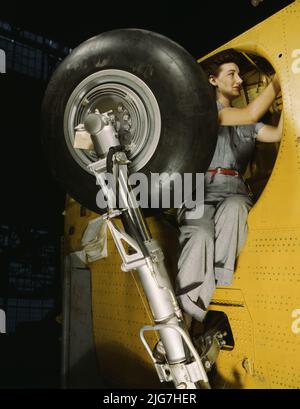 This woman worker at the Vultee-Nashville is shown making final adjustments in the wheel well of an inner wing before the installation of the landing gear, Nashville, Tenn. This [is] one of the numerous assembly operations in connection with the mass production of Vultee &quot;Vengeance&quot; dive bombers. Stock Photo