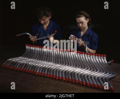 Capping and inspecting tubing: two women are shown capping and inspecting tubing which goes into the manufacture of the &quot;Vengeance&quot; dive bomber made at Vultee's Nashville division, Tennessee. The &quot;Vengeance&quot; (A-31) was originally designed for the French. It was later adopted by the R.A.F. and still later by the U.S. Army Air Forces. It is a single-engine, low-wing plane, carrying a crew of two men and having six machine guns of varying calibers. Stock Photo